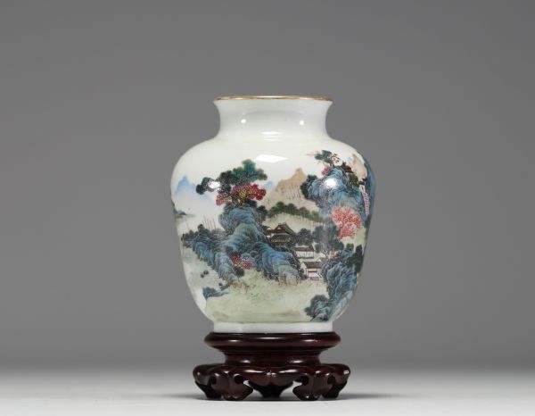 Chine - Vase en porcelaine polychrome à décor de paysage, socle en bois, marque au bleu sous la pièce.