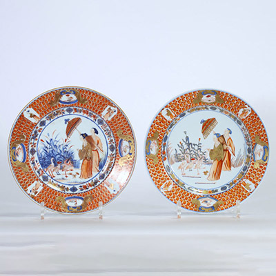 Rare paire d’assiettes en porcelaine de Chine à décor Imari de dames à l’ombrelle dans un jardin, oiseaux et insectes au revers, époque Yongzheng, XVIIIe siècle.
