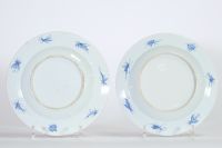 Rare paire d’assiettes en porcelaine de Chine à décor Imari de dames à l’ombrelle dans un jardin, oiseaux et insectes au revers, époque Yongzheng, XVIIIe siècle.
