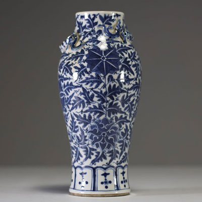 China - A white-blue porcelain vase decorated with flowers and foliage, chilong in relief on the shoulder, 19th century.