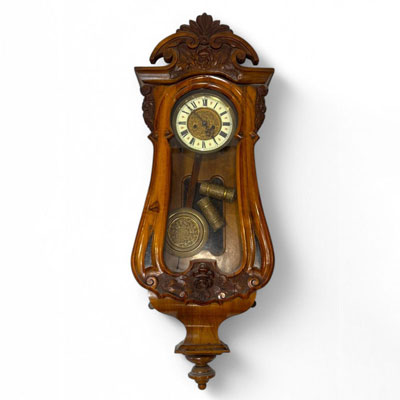Pendule d'applique en noyer sculpté et placage, caisse moulurée et vitrée, cadran à chiffres romains, fin XIXème.