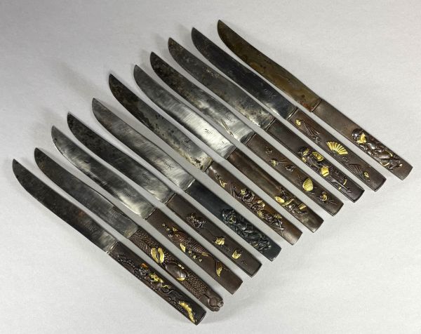 Japon - Suite de douze couteaux à fruits, manches kozuka en bronze et autres alliages métalliques, XIXème.