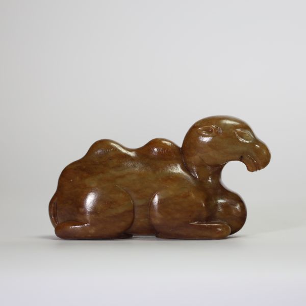 Chine, XIXe siècle. Chameau couché en jade néphrite brun, sculpté avec sobriété dans une posture stylisée, symbolisant la route de la soie et la persévérance.