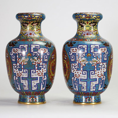 Rare paire de vases en cloisonné à décor de dragons affrontés dans des médaillons et motifs archaïsants, Chine, dynastie Qing, XIXe siècle Paire de vases balustres en laiton finement ornés d’émaux cloisonnés polychromes sur fond bleu turquoise, décorés de médaillons circulaires figurant des dragons affrontés sur fond rouge orné de nuées, encadrés de motifs archaïsants en registres, frises de ruyi,