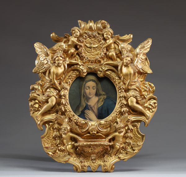 Cadre en bois et stuc doré orné de figures d'anges, de putti et d'une colombe du Saint Esprit, bénitier en partie basse.