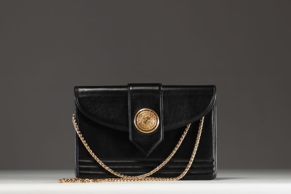 Yves SAINT-LAURENT - Black leather shoulder bag, gold chain and cabochon clasp.
