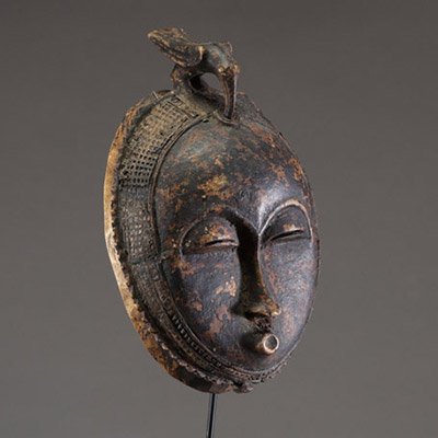 Afrique - Rare masque lune « Anglo Ba » Baoulé surmonté d’un animal, en bois dur sculpté, belle patine, Côte d’Ivoire, début XXème.