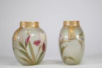 Paire de vases en verre translucide finement émaillés à décor de fleurs d’iris dans des tons pourpres, verts et blancs, soulignés de rehauts d’or. Frise en relief doré au col. Travail français de la p