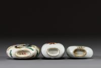 Chine - Ensemble de trois tabatières en porcelaine polychrome famille rose à décor de dignitaire, de fleurs, de grenouille et de dragon.