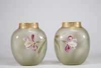 Paire de vases en verre translucide finement émaillés à décor de fleurs d’iris dans des tons pourpres, verts et blancs, soulignés de rehauts d’or. Frise en relief doré au col. Travail français de la p
