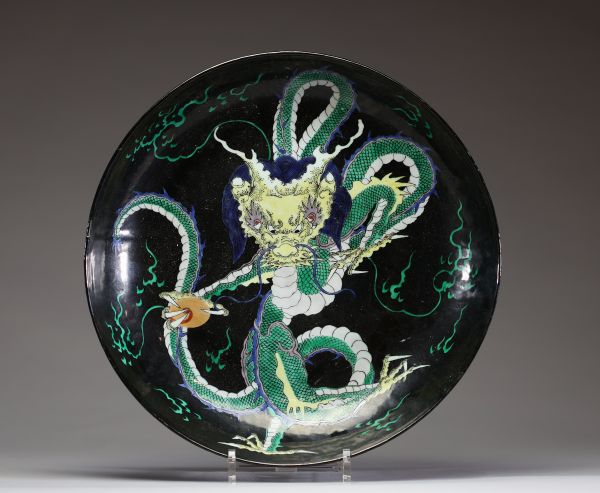 Chine - Plat en porcelaine polychrome émaillée noir et vert à décor de Dragon, époque Kangxi, marque au double cercle sous la pièce.  Important plat en porcelaine à fond noir, décoré en émaux polychro