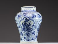 China - A white-blue porcelain baluster vase decorated with flowers, mugwort leaf mark within a double circle, Kangxi.