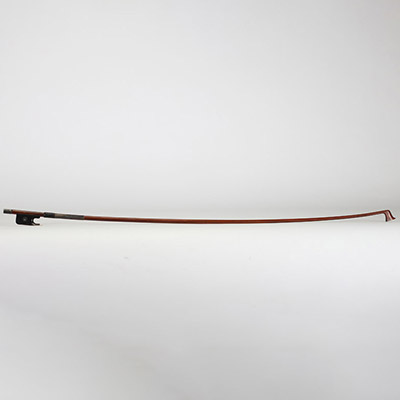 Victor Fétique (1872–1933) Archet de violon, baguette ronde en Pernambouc, montée en argent, hausse en ébène avec œil parisien, bouton à gorge simple. Gravé au fer : « Vtor FETIQUE à PARIS ».  Victor Fétique, archetier de renom actif à Paris au tournant du XXe siècle, est l’un des représentants les plus appréciés de l’école française. Élève de Bazin père, il collabora avec Caressa & Françai