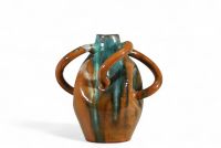 Arthur Craco (1869–1955) Vase à quatre anses Belgique, vers 1900 Grès vernissé, décor modelé, signé sur la base  Ce rare vase à quatre anses incarne à la fois l’esprit Art nouveau belge et une sensibilité marquée pour le Rustic Revival, mouvement prônant un retour à la matière brute, à l’artisanat et à l’authenticité des formes naturelles. Réalisé en grès vernissé, le vase dégage une forte présenc