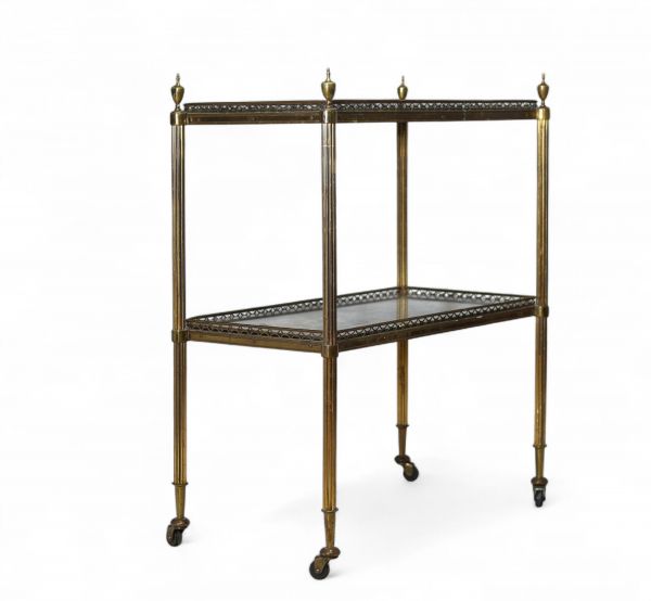 Desserte à deux plateaux attribuée à la Maison Jansen, vers 1940 Élégante desserte en métal doré à deux plateaux en miroir au mercure vieilli, montée sur roulettes. L’ensemble présente une structure à colonnettes cannelées surmontées de prises en toupie, typique des productions de la Maison Jansen dans les années 1940. Un meuble raffiné aux proportions équilibrées, mêlant fonctionnalité et style n