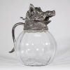 Valenti, Espagne, vers 1960 Aiguière en verre soufflé et monture en métal argenté à décor de sanglier.  Remarquable aiguière à panse godronnée en verre transparent, coiffée d’un couvercle sculptural en métal argenté figurant avec réalisme une tête de sanglier, gueule entrouverte et oreilles dressées.