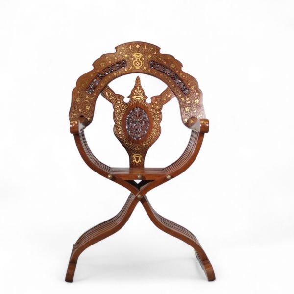 Fauteuil pliant syrien en bois incrusté de cuivre et signé, début du XXe siècle Structure en bois sculpté, incrustations de filets de cuivre et de laiton à décor floral stylisé