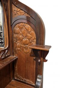 Vitrine Art Nouveau en bois clair, paire de panneaux latéraux sculptés de pommiers de part et d'autre d'un miroir, porte vitrée et poignées en laiton, vers 1900.