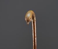 Carved wooden cane with bird's head motif, glass eyes.