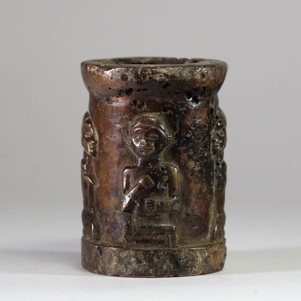 Rare récipient rituel ajouré en bronze massif, décoré de quatre figures humaines stylisées. Ethnie Bakongo, RD Congo.  Fonte à la cire perdue, patine ancienne. Objet rituel utilisé comme support pour fétiche ou logement symbolique de bilongo (substances de pouvoir) ? H. 13,5 cm – Poids : 4,5 kg. Première moitié du XXe siècle ou antérieur. Collecté sur site par A.S., St Idesbald, début des années 1