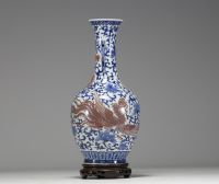 China - A white-blue porcelain vase decorated with a dragon and an iron-red phoenix, mark under the piece, 18th century.