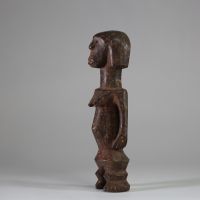 Statuette Zandé « Yanda » ( société mani) , RD Congo. Bois. De forme élancée mais sur des jambes courtes et trapues, les pieds bien définis. Le ventre est légèrement gonflé au niveau de l’ombilic, ce qui est une caractéristique courante de l’art Zandé. Les bras le long du corps. Belle patine usée par l’usage. H : 28,5 cm.  Collecté sur site par A.S., St Idesbald, début des années 1950