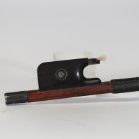 Victor Fétique (1872–1933) Archet de violon, baguette ronde en Pernambouc, montée en argent, hausse en ébène avec œil parisien, bouton à gorge simple. Gravé au fer : « Vtor FETIQUE à PARIS ».  Victor Fétique, archetier de renom actif à Paris au tournant du XXe siècle, est l’un des représentants les plus appréciés de l’école française. Élève de Bazin père, il collabora avec Caressa & Françai