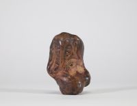 Fragment sculpté en pierre représentant une figure anthropomorphe à trompe, probablement Ganesh. Inde ou Himalaya, XIXe siècle. La composition s’intègre harmonieusement aux irrégularités naturelles du galet, caractéristique d’un travail rituel populaire, probablement issu d’un contexte religieux localisé dans le nord de l’Inde ou les régions himalayennes. L’objet pourrait avoir servi de talisman p