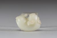 Chine - Sculpture en jade blanc représentant un chien chinois, fin de la dynastie Qing Sculpture délicatement taillée dans un jade blanc de belle qualité, figurant un chien chinois couché, le corps ramassé et la tête tournée vers l’avant. Le jade présente une teinte douce et homogène, typique des œuvres réalisées à la fin de la dynastie Qing. Le sujet animalier, fréquent dans l’art chinois, symbol