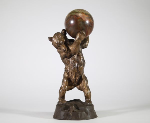 Sculpture animalière – L’ours et la sphère Charmante composition en bronze patiné figurant un petit ours dressé sur ses pattes arrière, soutenant une sphère en pierre polie, son regard tourné vers une grenouille blottie à ses pieds. L’ensemble repose sur une base rocailleuse. Cachet de fonderie française sur le revers. Travail fantaisiste de la première moitié du XXᵉ siècle, dans le goût des produ