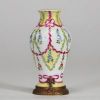 Sèvres - Petit vase en porcelaine à décor de guirlandes de fleurs sur monture en bronze doré, XIXème, marque sous la pièce.