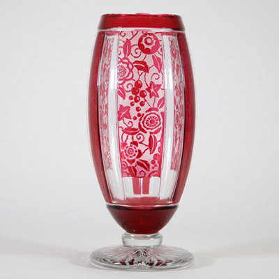 Vase Art Déco en cristal doublé rouge à décor géométrique et floral, attribué à Baccarat Vase de forme balustre en cristal doublé rouge rubis, à décor géométrique structuré par des pans coupés verticaux alternant motifs lisses et réserves gravées à l’acide d’un décor floral stylisé. Le corps repose sur un piédouche circulaire taillé en étoile.