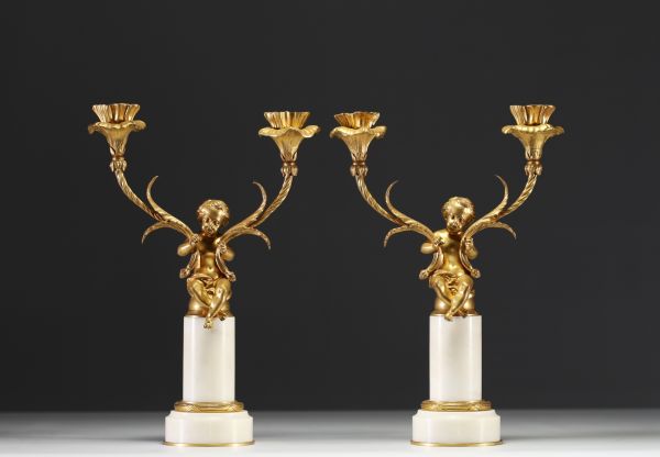 A pair of ormolu candelabra with cherubs and two arms, alabaster base, Napoleon III period.