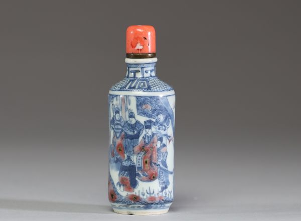 Chine - Tabatière en porcelaine blanc bleu et rouge fer à décor de dignitaires, bouchon en corail.
