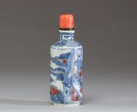 Chine - Tabatière en porcelaine blanc bleu et rouge fer à décor de dignitaires, bouchon en corail.