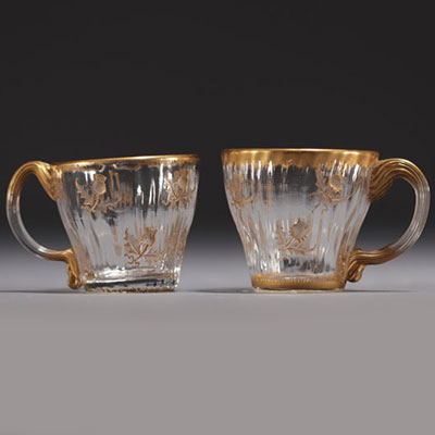 DAUM Nancy - Paire de petites tasses en verre à décor gravé de chardons rehaussé à l'or, signées.