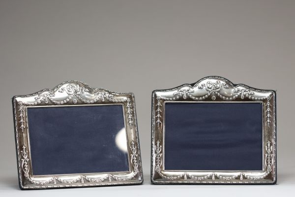 Paire de cadres en argent repoussé à décor de guirlandes de fleurs de style Louis XVI.