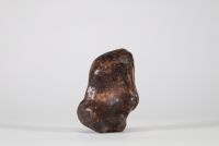 Fragment sculpté en pierre représentant une figure anthropomorphe à trompe, probablement Ganesh. Inde ou Himalaya, XIXe siècle. La composition s’intègre harmonieusement aux irrégularités naturelles du galet, caractéristique d’un travail rituel populaire, probablement issu d’un contexte religieux localisé dans le nord de l’Inde ou les régions himalayennes. L’objet pourrait avoir servi de talisman p