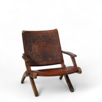 Angel Pazmiño .Ensemble de mobilier comprenant quatre fauteuils, une table basse et un pouf Bois massif et cuir patiné à décor repoussé, Équateur, vers 1960.