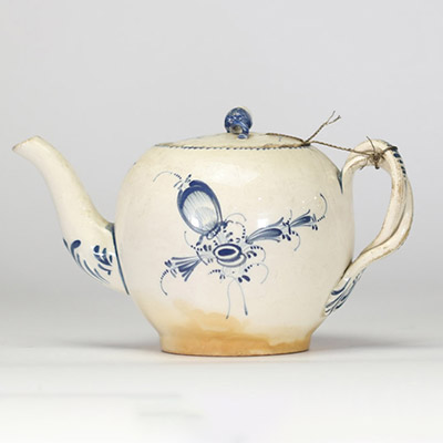 Boch Luxembourg, fin XVIIIe – début XIXe siècle Petite théière en porcelaine fine à décor bleu Théière de forme globulaire à décor peint en bleu sous couverte de réserves rocaille, feuillages et fleurettes stylisées.