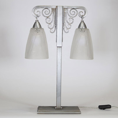 J. Vandôme & Muller Frères Lunéville, vers 1930 Lampe Art Déco à deux lumières en métal martelé nickelé et verrerie signée.  Structure en potence à deux bras terminés par d’élégantes volutes martelées, surmontant un fût vertical en métal à décor rayonnant. La base rectangulaire est signée J. Vandôme, artisan ou maison d’édition réputée pour ses œuvres de ferronnerie décorative dans les années 1930