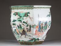 Rare et spectaculaire vase en porcelaine de forme hexagonale, décoré en émaux de la famille verte. Chaque pan du corps présente une scène animée mettant en scène des dignitaires, serviteurs et immortels dans un paysage arboré ponctué de pins, rochers et nuées stylisées. Les personnages, finement détaillés, sont représentés à cheval, à pied ou en conversation, dans un esprit narratif typique de la