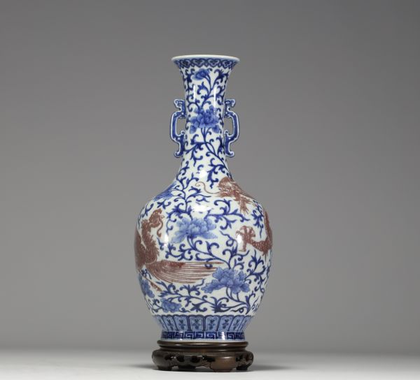 China - A white-blue porcelain vase decorated with a dragon and an iron-red phoenix, mark under the piece, 18th century.