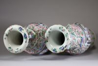 Chine - Paire de grands vases en porcelaine polychrome famille rose à décor de courtisanes, de pêches et de fleurs, dynastie Qing, XIXème.