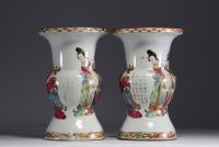 China - A pair of famille rose porcelain vases decorated with dignitaries, courtesans and poems, 19th century.