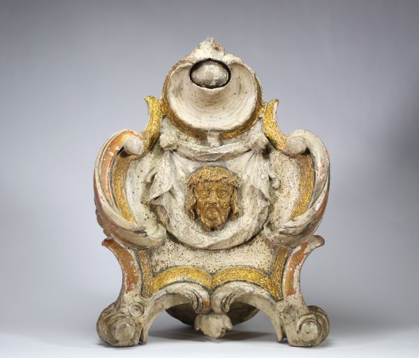 Élément d’ornement liturgique en bois sculpté, doré et polychromé, probablement Italie ou Espagne, XVIIIe siècle Bois sculpté en fort relief, traces de dorure et de polychromie, décor à tête du Christ en médaillon, encadrement chantourné.
