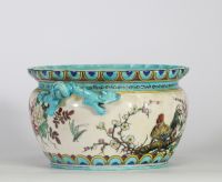 Théodore Deck (1823–1891) Importante jardinière en faïence émaillée, à décor polychrome d’inspiration extrême-orientale représentant un coq, des oiseaux, des papillons et des branchages fleuris en léger relief, sur fond crème. Frise supérieure ornée de motifs géométriques bleus et or. Ansés latérales en forme de dragons stylisés émaillés turquoise.