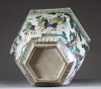 Rare et spectaculaire vase en porcelaine de forme hexagonale, décoré en émaux de la famille verte. Chaque pan du corps présente une scène animée mettant en scène des dignitaires, serviteurs et immortels dans un paysage arboré ponctué de pins, rochers et nuées stylisées. Les personnages, finement détaillés, sont représentés à cheval, à pied ou en conversation, dans un esprit narratif typique de la