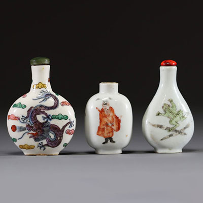 Chine - Ensemble de trois tabatières en porcelaine polychrome famille rose à décor de dignitaire, de fleurs, de grenouille et de dragon.