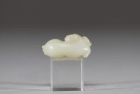 Chine - Sculpture en jade blanc représentant un chien chinois, fin de la dynastie Qing Sculpture délicatement taillée dans un jade blanc de belle qualité, figurant un chien chinois couché, le corps ramassé et la tête tournée vers l’avant. Le jade présente une teinte douce et homogène, typique des œuvres réalisées à la fin de la dynastie Qing. Le sujet animalier, fréquent dans l’art chinois, symbol